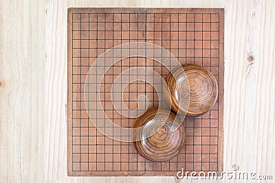 Two wooden bowls over empty go game board Stock Photo