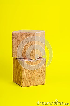 Two wooden cube square on yellow background copyspace Stock Photo