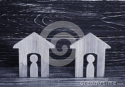 Two wooden houses with people on a black background. The concept of the district, its neighbors. Good-neighborly relations. Stock Photo