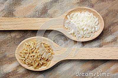 Two wooden spoons with white and brown rice grains Stock Photo