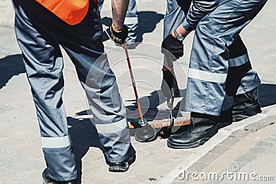 Two workers of emergency gas service, checking concentration of gas in the sewer Stock Photo