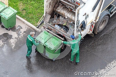 Two workers loading domestic waste in waste collection truck Editorial Stock Photo