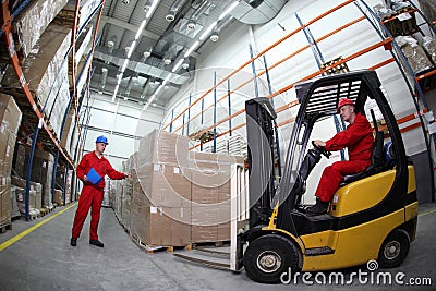 Two workers loading pallets with forklift truck Stock Photo