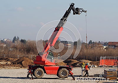 Two workers with a telescopic handler loader assemble concrete slabs for the new building Editorial Stock Photo