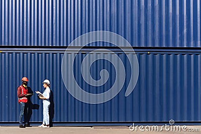 Two workers wear safety vest and helmet discus at logistic shipping cargo container yard workplace. African American engineer man Stock Photo