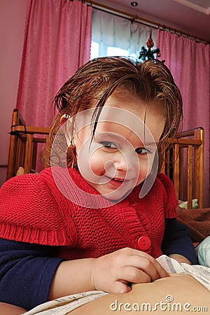 A two-year-old girl lies on the mother and drinks breast milk, the time of unity of mother and child Stock Photo