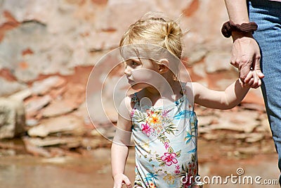 A Two Year Old Holds Hands with Mommy Stock Photo