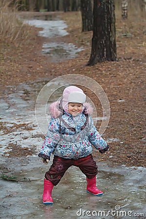 Two years old girl playing in icy puddle Stock Photo