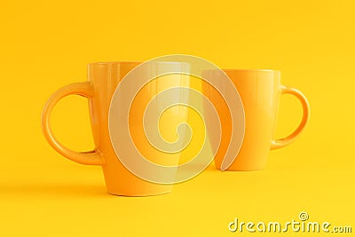 Two yellow coffee cups on yellow background Stock Photo