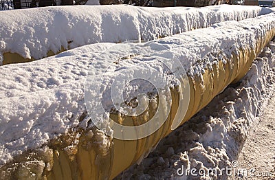 Two yellow frozen pipes in winter closeup Stock Photo