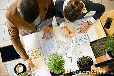 Two young architects discussing building plans during a meeting in an office Stock Photo