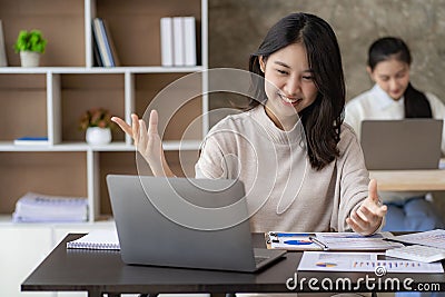 Two young Asian female accountants discuss working Stock Photo