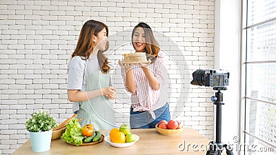 Two young asian women food bloggers talking while recording video with happy moment, vlog concept, people and technology Stock Photo