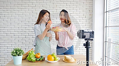 Two young asian women healthy food bloggers talking while recording video with happy moment, vlog concept, people and technology Stock Photo