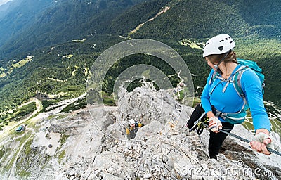 Two young attractive mountain climbers on very exposed Via Ferrata in the Dolomites of Italy Stock Photo