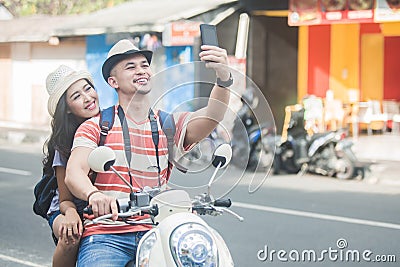 Two young backpackers taking selfies using mobilephones camera w Stock Photo