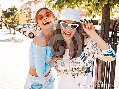 Two young beautiful smiling hipster girls in trendy summer clothes Stock Photo