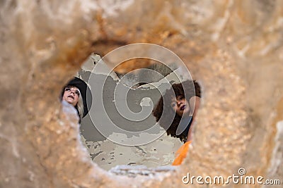 Two young and beautiful witches can be seen through the hole in the roof of a ruined and abandoned building. The women are holding Stock Photo