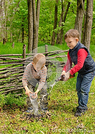 Two young boys extinguishing a small fire Stock Photo