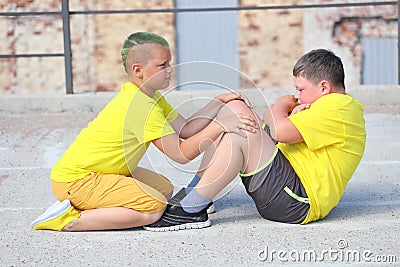 two young boys in yellow T-shirts are training. Training of abdominal muscles Stock Photo