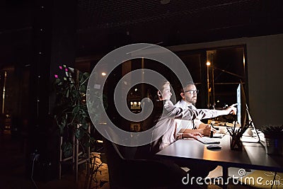Businesspeople in the office at night working late. Stock Photo