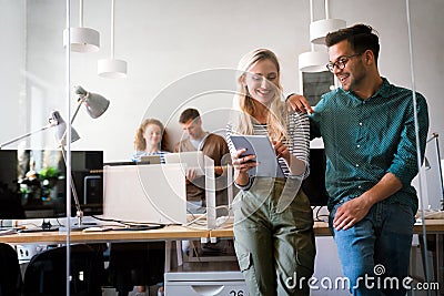 Two young businesspeople using a digital tablet while standing in a boardroom. Stock Photo