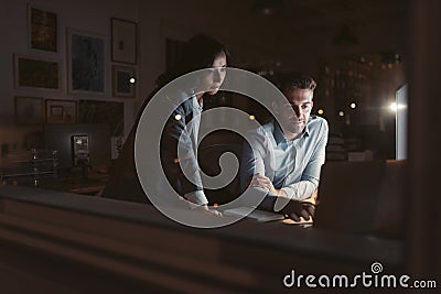 Two young businesspeople working late together in an office Stock Photo