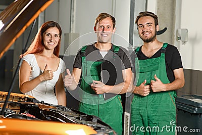 Two young car service workers, and a beautiful young girl show o Stock Photo