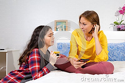 Two young Caucasian women are using their smartphones and discussing something. Concept of relationships , LGBT and communication Stock Photo