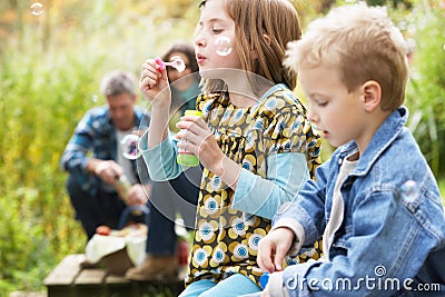Two Young Children Blowing Bubbles outisde Stock Photo
