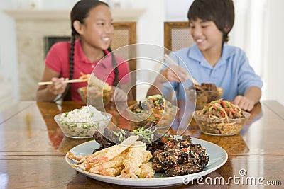 Two young children eating chinese food Stock Photo