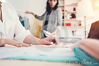 Two young clothing designer working in sewing design bureau. Businesswoman sew new fashion clothes. Small business Stock Photo