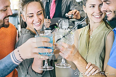 Two young couple in love toasting cocktails in a bar - Happy friends dating together making cheers with taste drinks Stock Photo