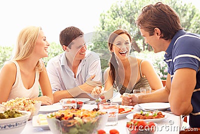 Two young couples eating outdoors Stock Photo