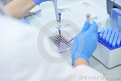 Two Young Female and male Laboratory scientists working at lab with test tubes and microscope, test or research in clinical Stock Photo