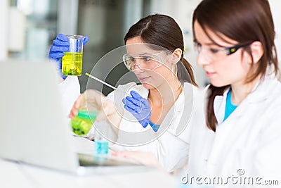 Two young female researchers carrying out experiments in a lab Stock Photo