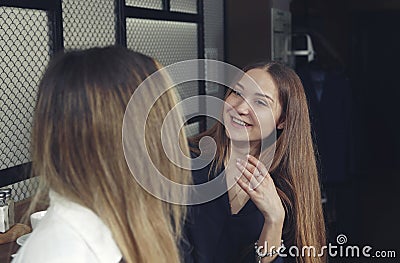 Two young girls are happy and laughing have a tea time at the counter in a cafe Stock Photo