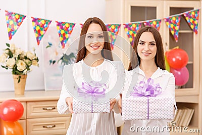 Two young girls are offering presents Stock Photo