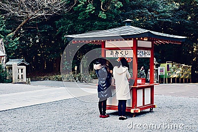 Two young girls are praying at a temple in Japan Kagoshima Editorial Stock Photo