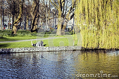 Two young guys hipsters chilling on green grass outside in park at sundown, relaxing people lifestyle concept, couple Editorial Stock Photo