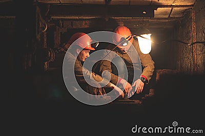 Two young guys in a working uniform and protective helmets Stock Photo