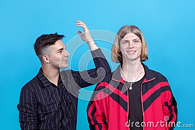 Two young handsome guys, talk to each other, smiling. Gay relationship or close friendship. Stock Photo