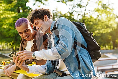 Two young handsome stylish laughing boys with phone watching something Stock Photo
