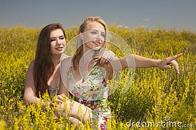 Two young happy friends siting on grass and smile Stock Photo