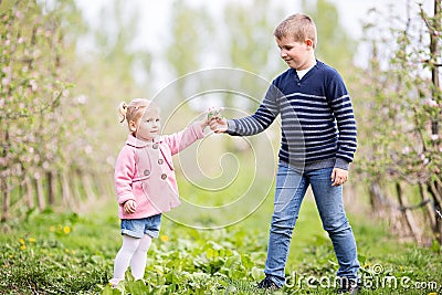 Two young kids in a park, holding flower Stock Photo