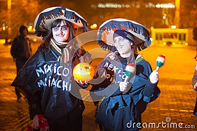 Two young ladies dressed in festive costumes singing Editorial Stock Photo