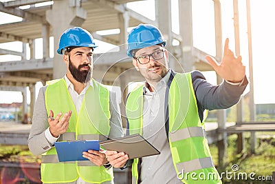 Two young male architects or business partners talking on a construction site Stock Photo