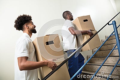 Two Young Male Worker Holding Cardboard Boxes Stock Photo