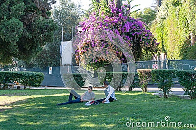 Two young males lying on the green lawn in the park Editorial Stock Photo