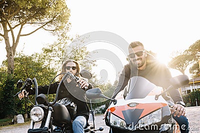 Two young men sitting on different motorcycles on the street without helmets Stock Photo